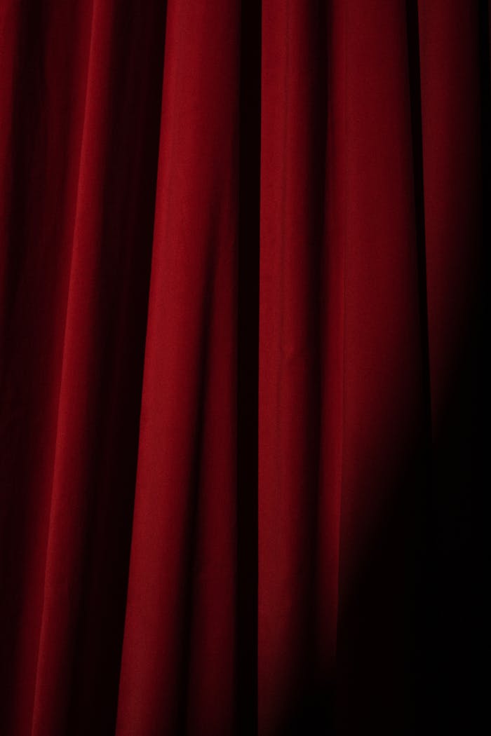 heros-img Deep red velvet theater curtain, perfect for presentations or artistic backgrounds.